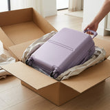 Bugatti Salerno 20-inch carry-on in Shadow Lilac being unboxed from a cardboard shipping box.